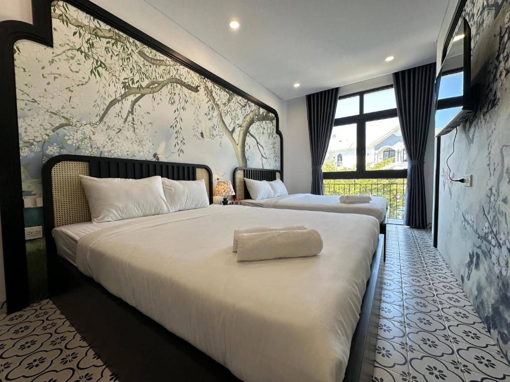 a bedroom with two beds and a large wall mural at Mộc Lâm Homestay in Phú Quốc