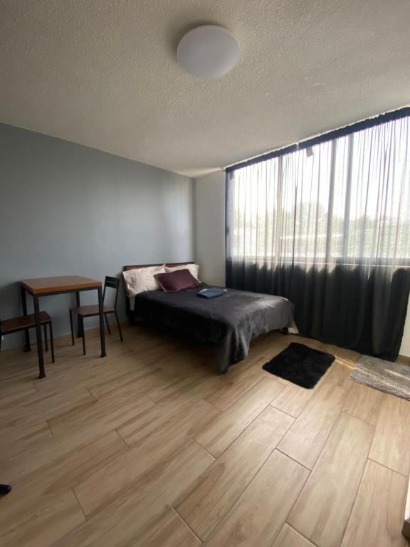 een slaapkamer met een bed, een tafel en een raam bij Agradable,comodo,centrico apartamento en CDMX 8 in Mexico-Stad