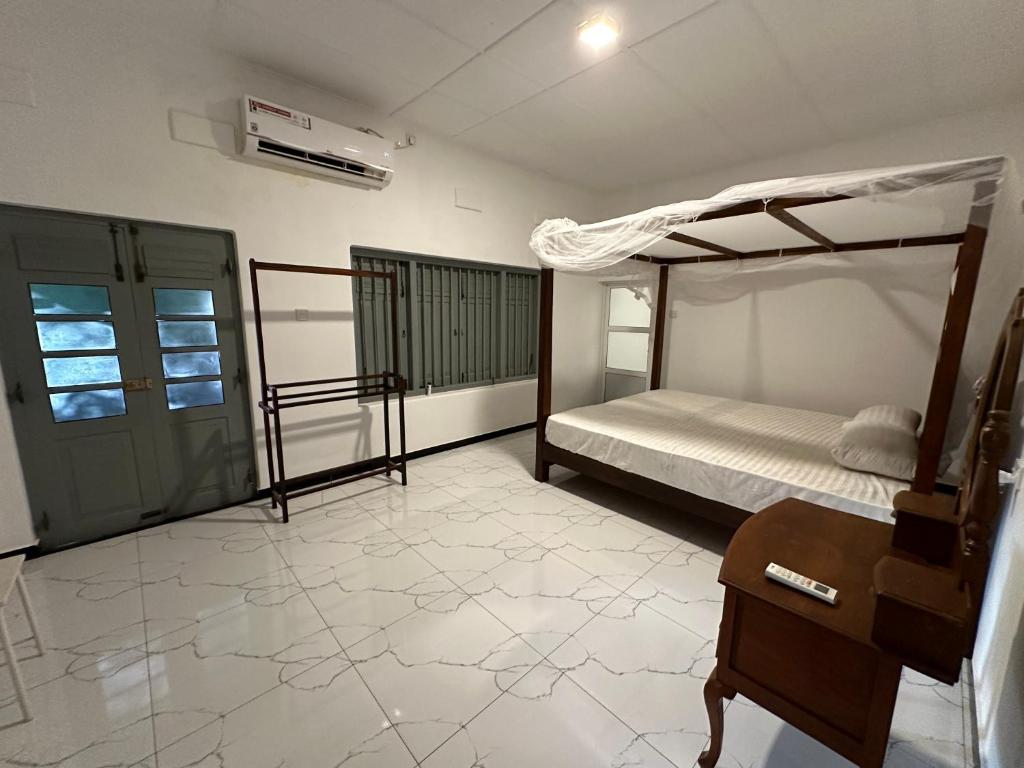 a bedroom with a bed and a table and a desk at Villa 95 in Dickwella