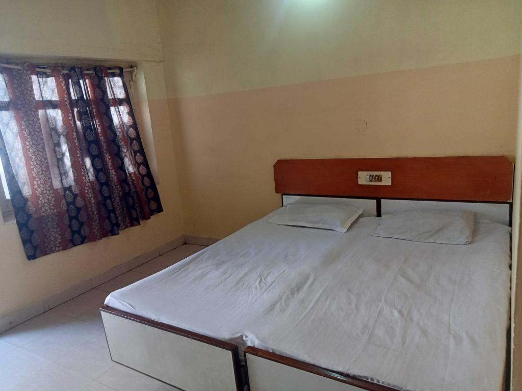 a small bed in a room with a window at OYO Hotel New Sri Sai Amaravati Lodge in Hyderabad
