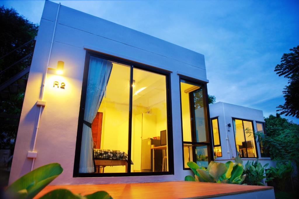 mały dom z dużymi szklanymi oknami na boku w obiekcie Rivercreek Estate w mieście Kaeng Kachan
