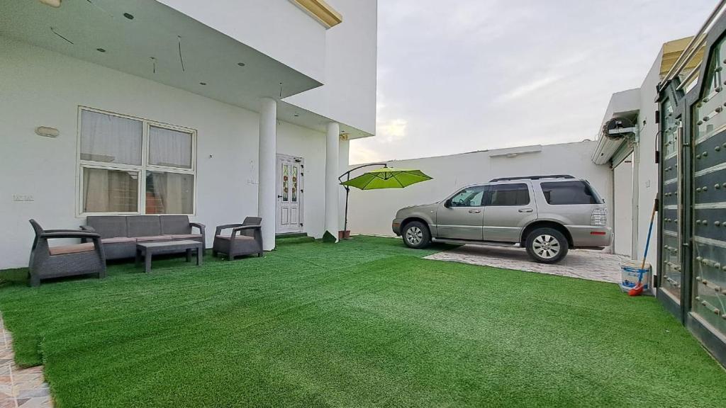 ein Auto parkt auf einem Rasen in einem Haus in der Unterkunft ستوديو دور ارضي كامل بمطبخ وحوش وكراج خاص. in Al Hofuf