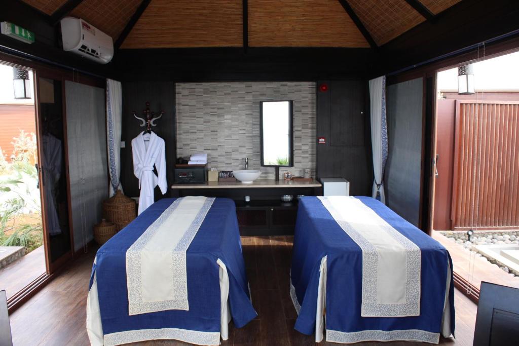 The Ritz-Carlton Ras Al Khaimah, Al Hamra Beach tesisinde bir odada yatak veya yataklar
