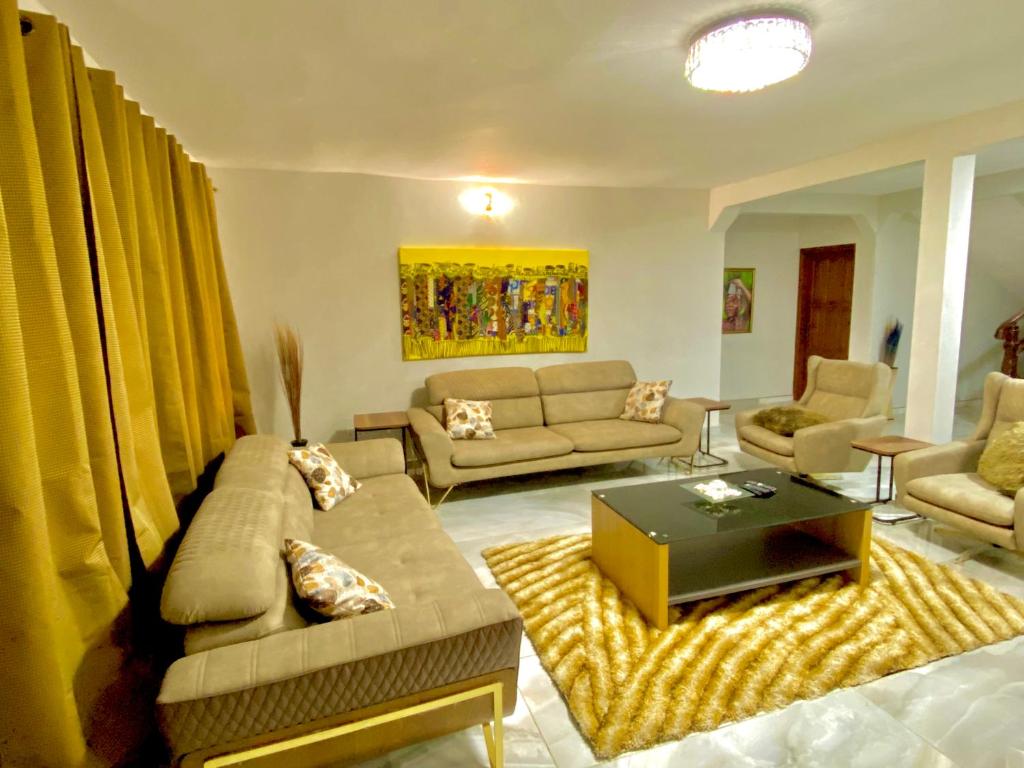 ein Wohnzimmer mit einem Sofa und einem Tisch in der Unterkunft Amazing Grace Villa in Accra