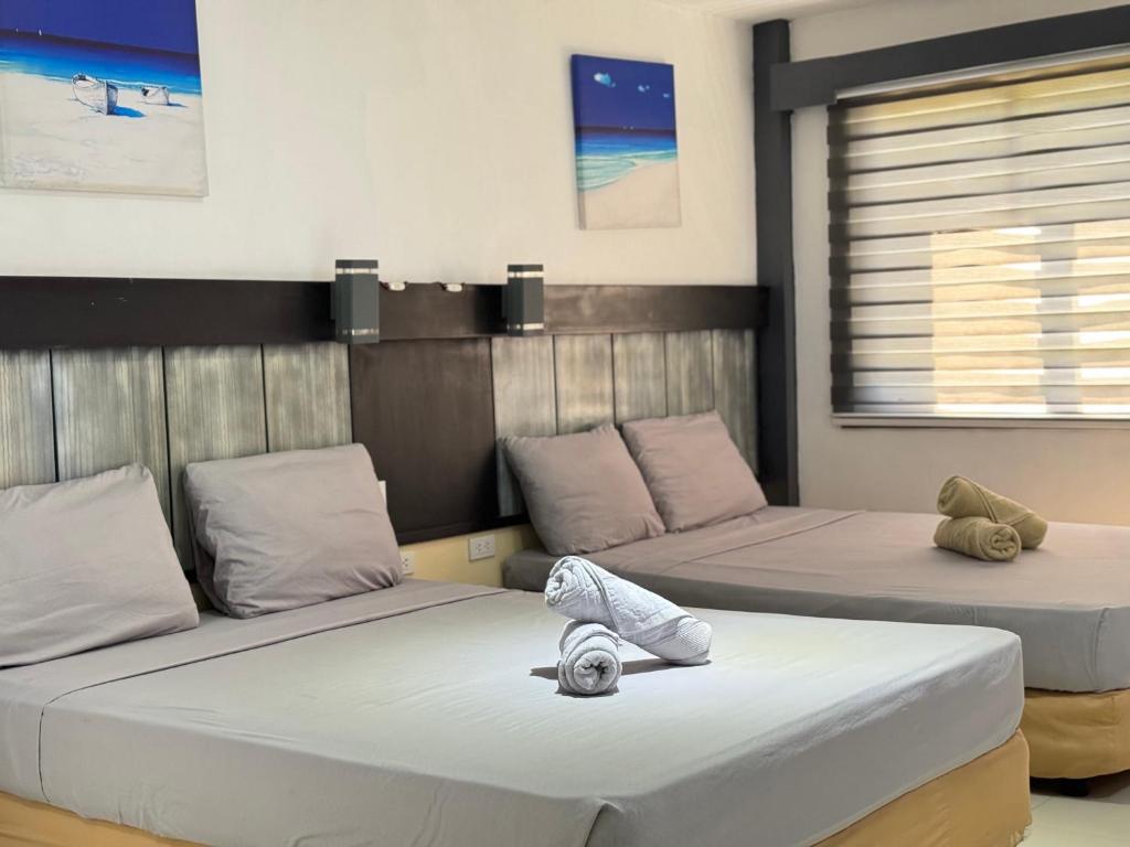 2 camas con almohadas en una habitación en Dante's Hideaway Guest House en Boracay