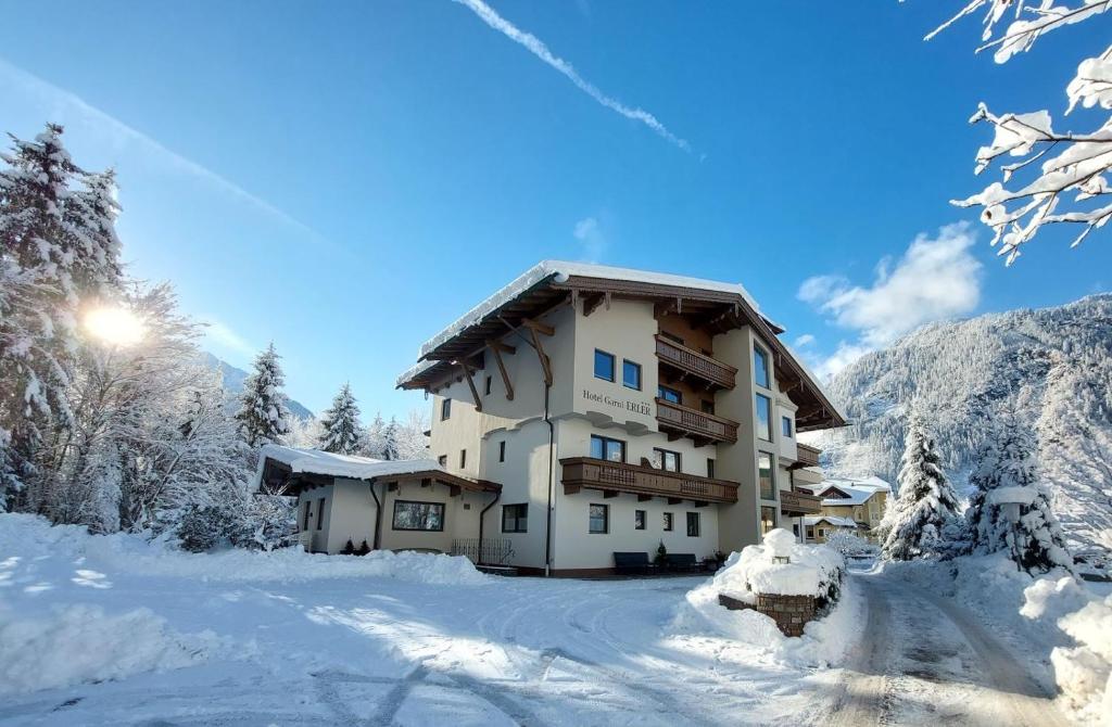 un edificio en la nieve con árboles nevados en Hotel Garni Erler, en Mayrhofen