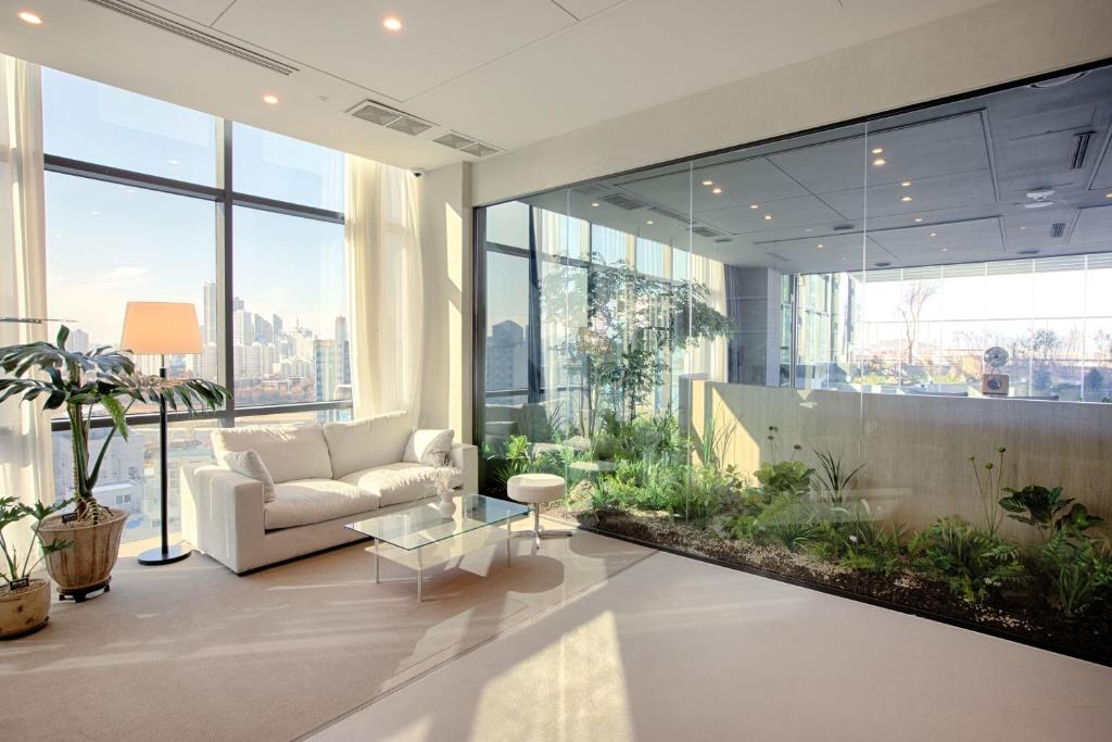 a living room with a couch and some plants at Union Hotel in Seoul