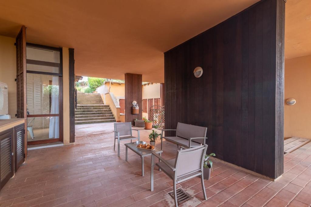 - un salon avec une table et des chaises ainsi qu'un escalier dans l'établissement Secret Garden House - Happy Rentals, à Marina di Portisco