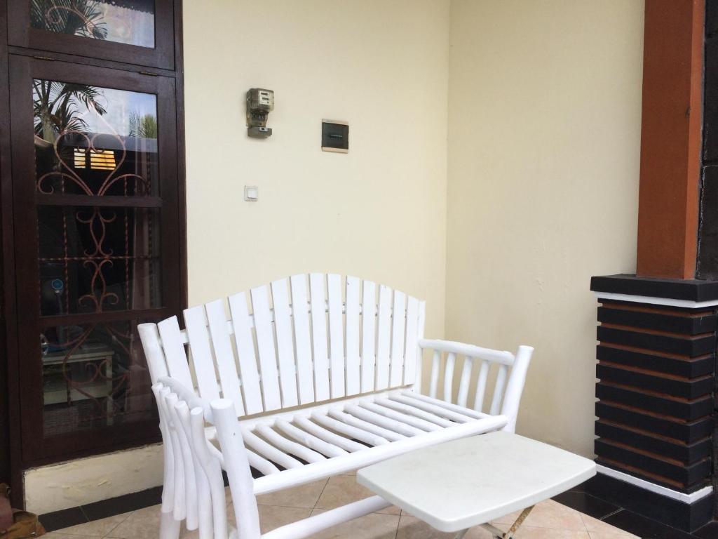 biała ławka siedząca przed drzwiami w obiekcie Simple apartment 1 w mieście Seminyak
