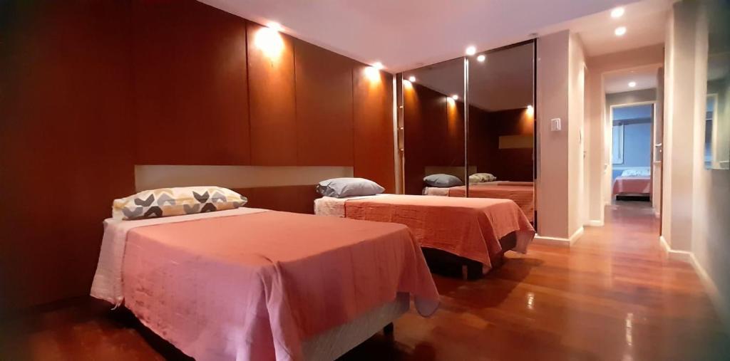 Habitación de hotel con 2 camas y espejo en DEPARTAMENTO ABASTO en Buenos Aires