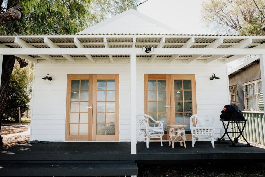 a white house with white chairs and a pergola at Sur Mer Studio - Seaside Escape in Dunsborough