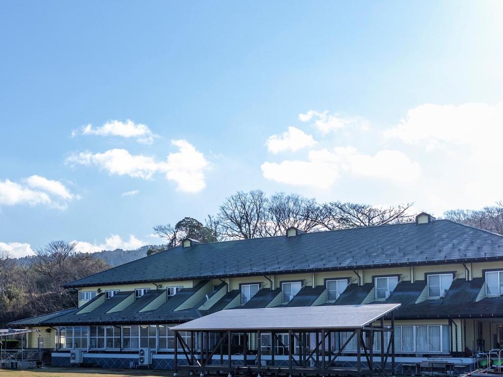 um grande edifício com um telhado preto em Fureaihouse Shiodu no Sato em Sado