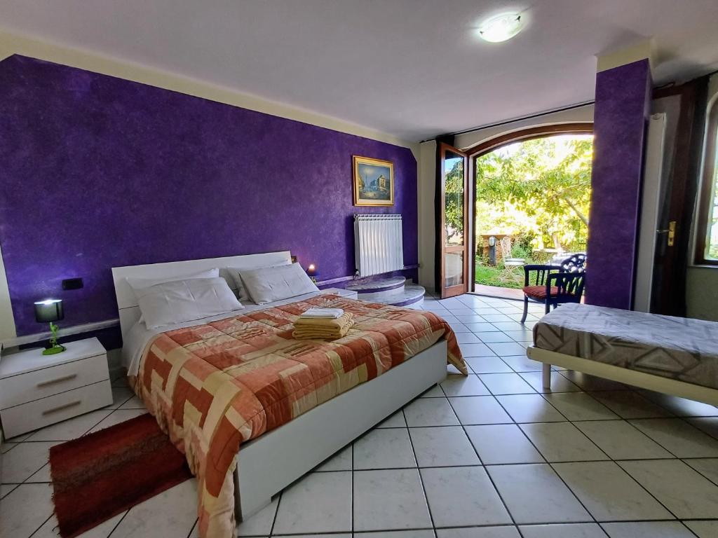 um quarto com uma cama e uma parede roxa em Monti e Mare em Lanusei