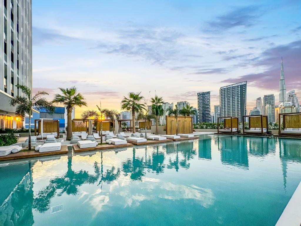 a swimming pool with chairs and a city skyline at FAM Living - Upside Living - WFH Friendly-Business Bay in Dubai