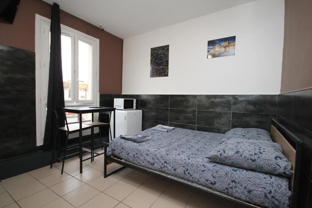 a bedroom with a bed and a table and a chair at 07 - Chambre proche Paris et Transports avec TV WIFI in Saint-Denis