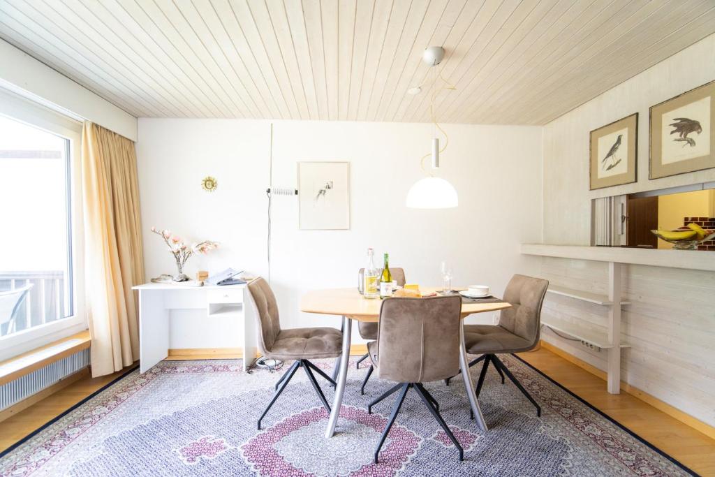 a dining room with a table and chairs at Brentschpark 28 in Scuol