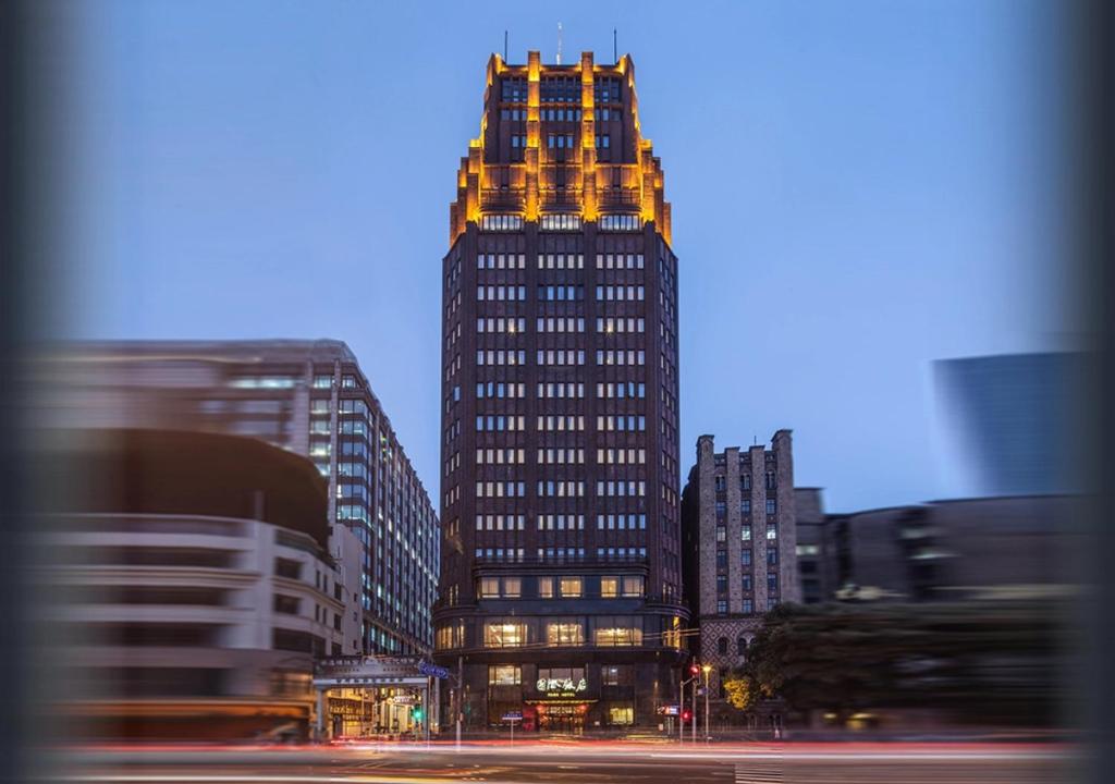 um edifício alto numa cidade à noite em Jin Jiang Park Hotel em Xangai