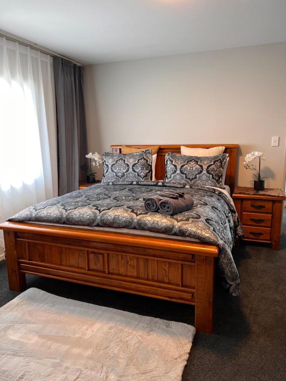 a bedroom with a large wooden bed in a room at Willowbank Motel in Kaikoura