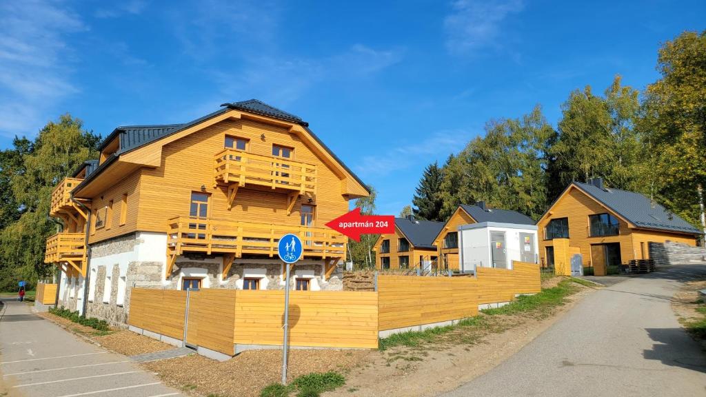 a wooden house with a sign in front of it at Pohoda Na Hůrce in Horní Planá