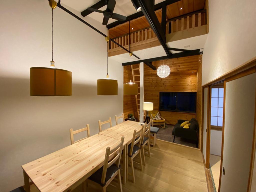 a dining room with a long wooden table and chairs at FTH Moon Light 3min to Sta. in Shimo-yoshida