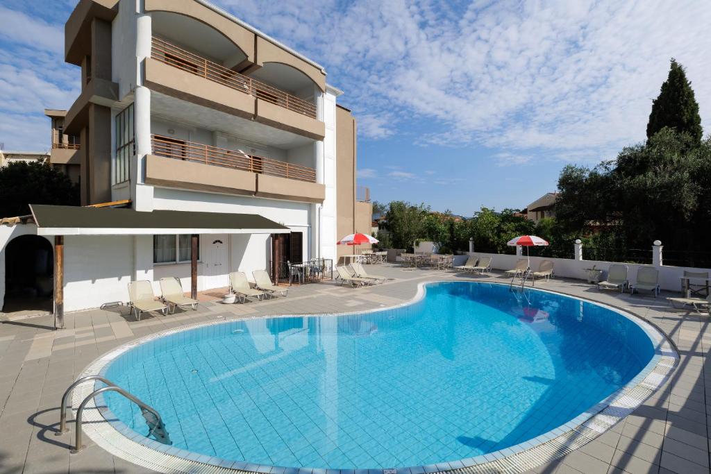 a large swimming pool in front of a building at Louvre Hotel in Gouvia