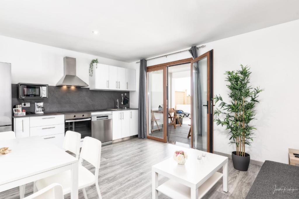 cocina y comedor con armarios blancos y mesa en Cerca Nueva, en Las Manchas