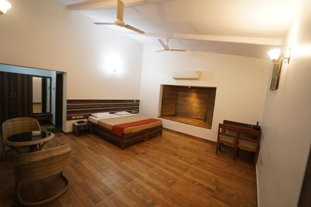 a bedroom with a bed and a desk in a room at Wild Woods Tiger Resort in Nagpur