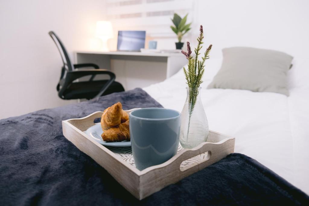 een dienblad met een kopje en croissants op een bed bij Piso compartido Delyrent, SFJ in Jaén