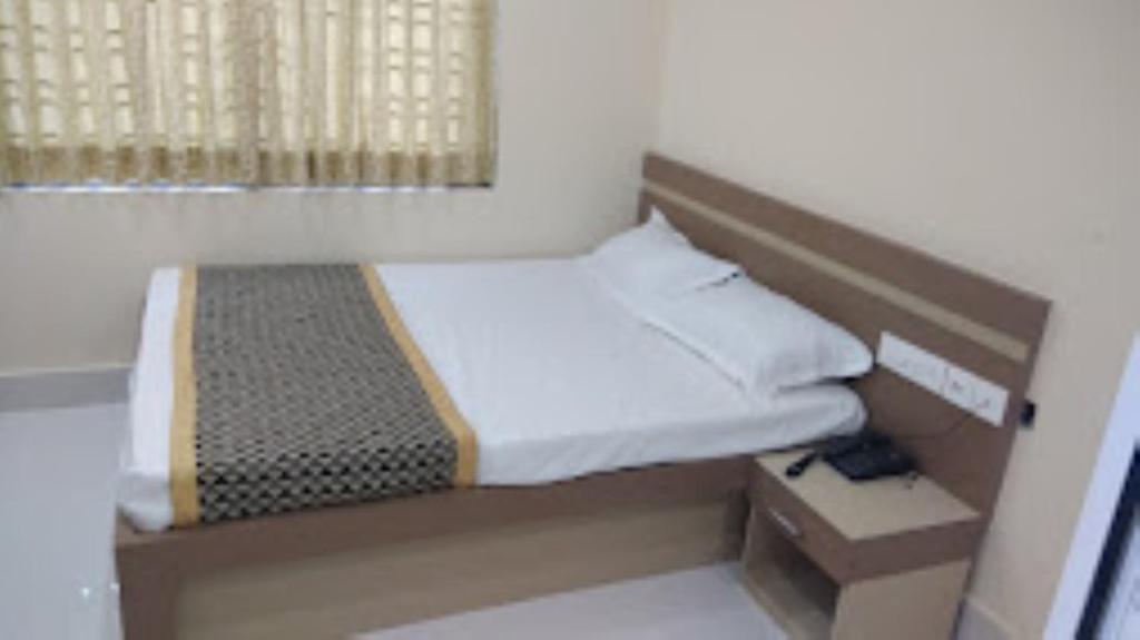 a small bedroom with a bed and a window at Triumph inn Bhubaneswar in Bhubaneshwar
