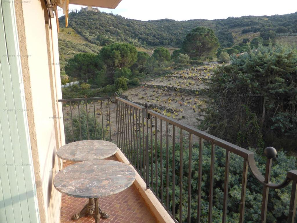 a balcony with a table and a view of a river at 4PA72 - Magnifique appartement pour 4 dans résidence avec piscine et parking in Collioure