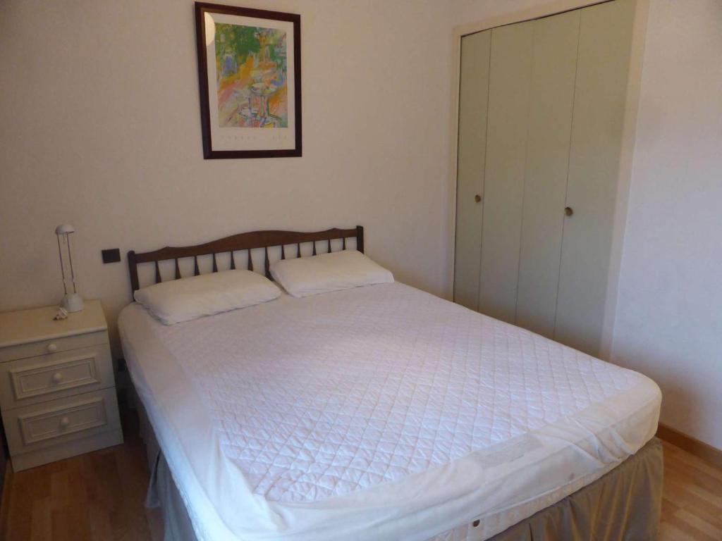 a bedroom with a white bed and a night stand at 4PA72 - Magnifique appartement pour 4 dans résidence avec piscine et parking in Collioure