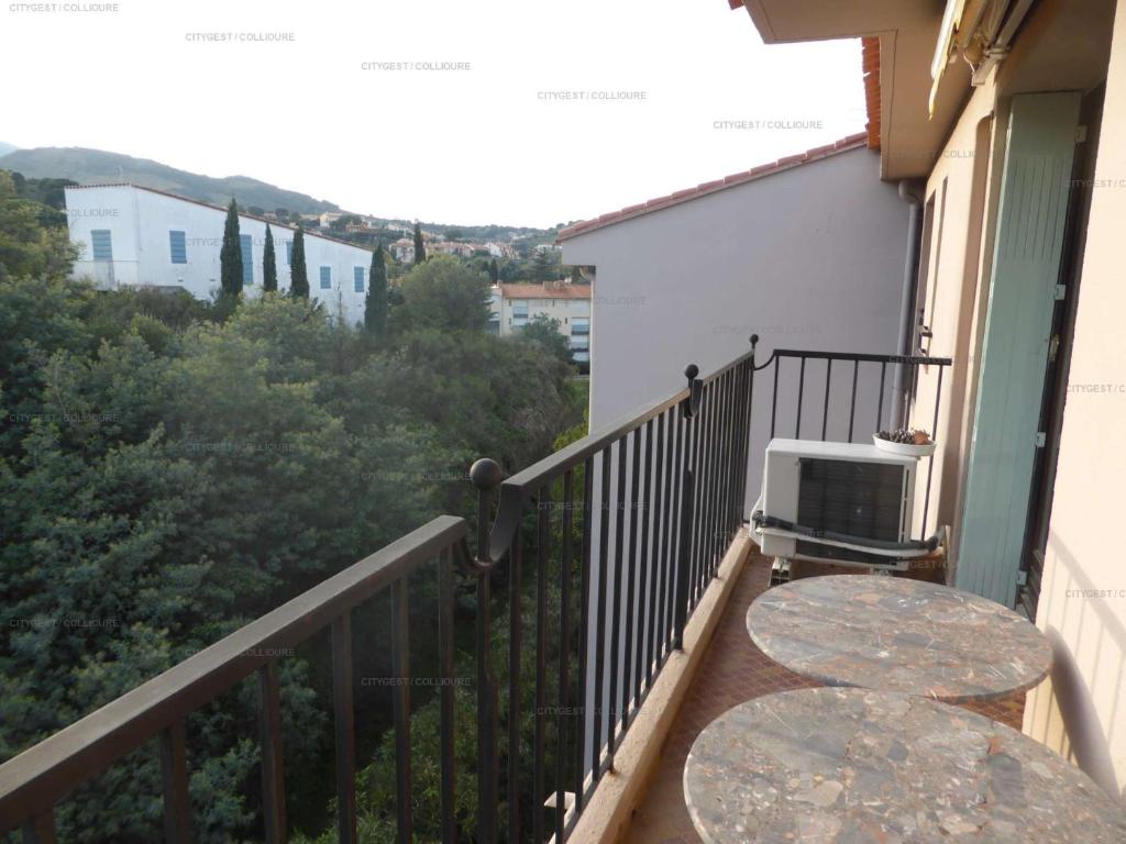 a balcony with a table and a table and a view at 4PA72 - Magnifique appartement pour 4 dans résidence avec piscine et parking in Collioure