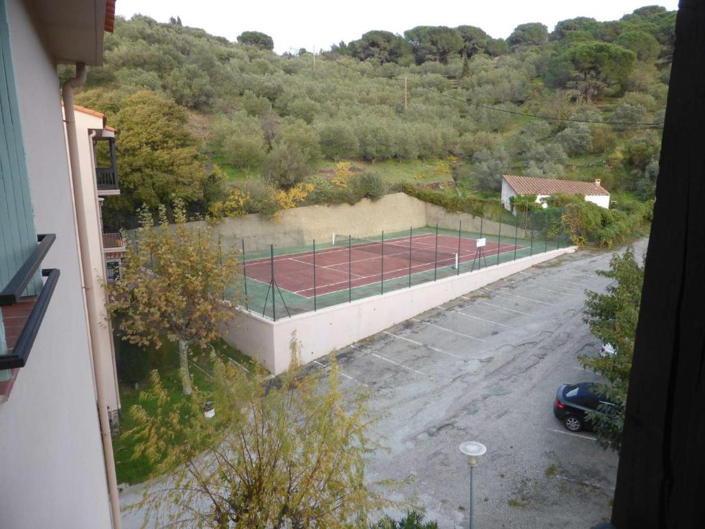a tennis court in a parking lot next to a building at 4PA72 - Magnifique appartement pour 4 dans résidence avec piscine et parking in Collioure