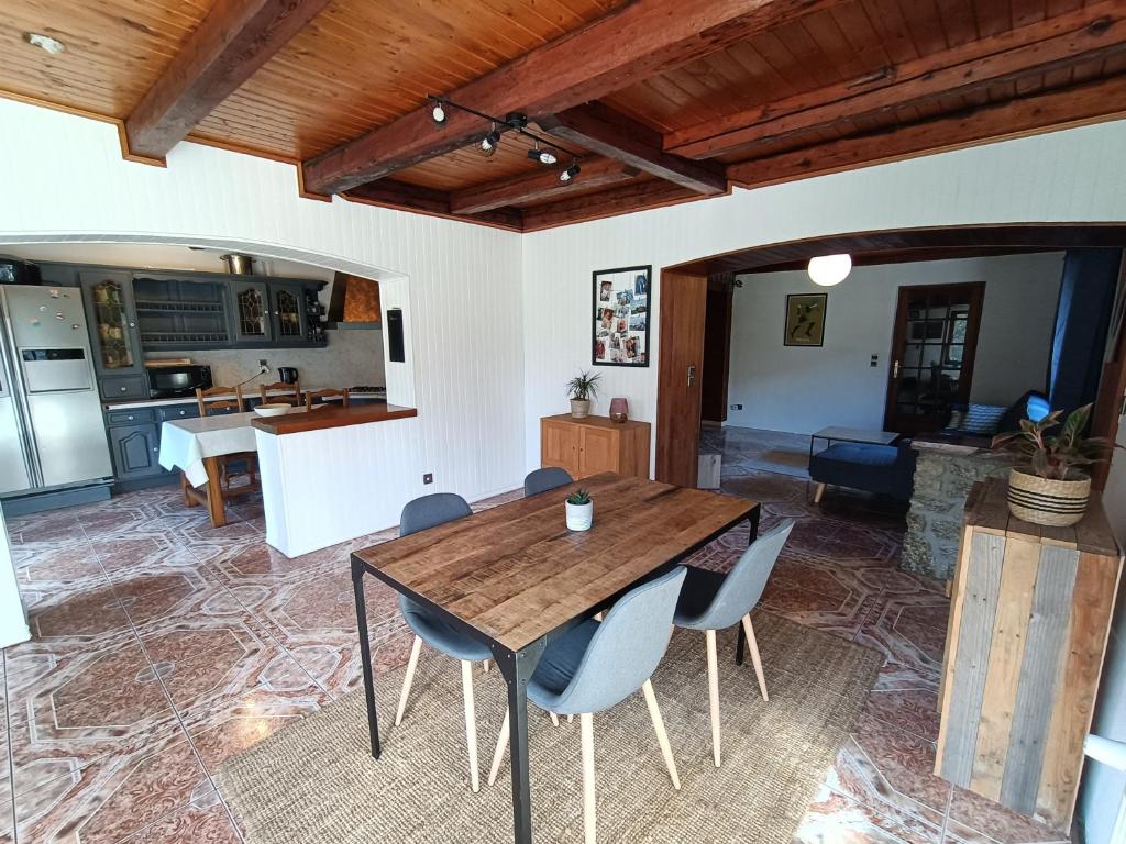 cocina y comedor con mesa de madera y sillas en Appartement cozy 100m2 dans chalet savoyard, en Magland