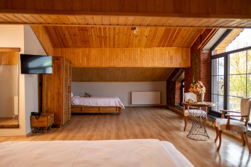 Eylül Butik Hotel في تونجيلي: غرفة نوم بسرير وتلفزيون في غرفة