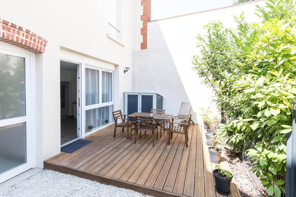 a wooden deck with a table and chairs on it at Tranquilis - Studio hypercentre terrasse parking in Reims