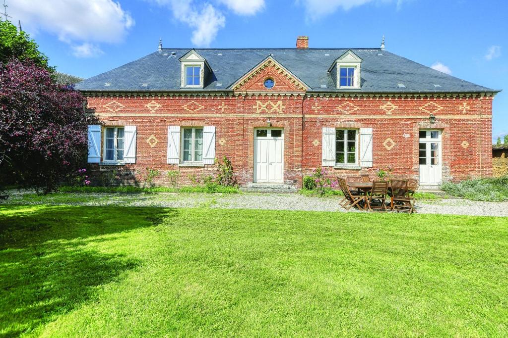 uma grande casa de tijolos vermelhos com relva em La Goupillère - Ancienne école totalement rénovée 