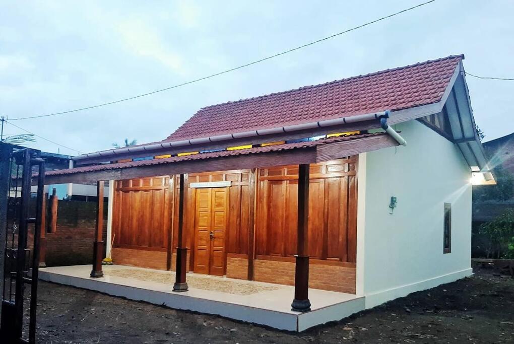 a small house with a brown roof at Kampung house Godean Sleman Yogyakarta in Godean