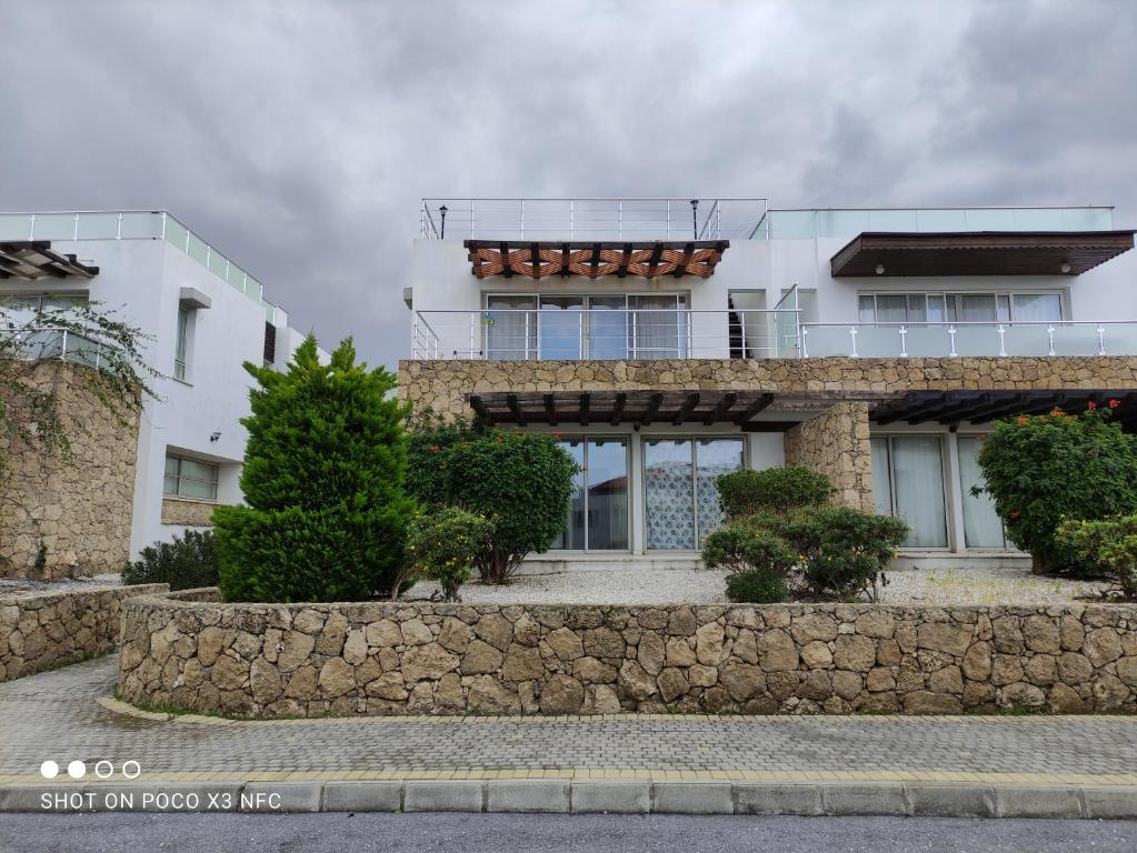 a building with a stone wall in front of it at Holiday Dreams Sweetwater Bay in Akanthou