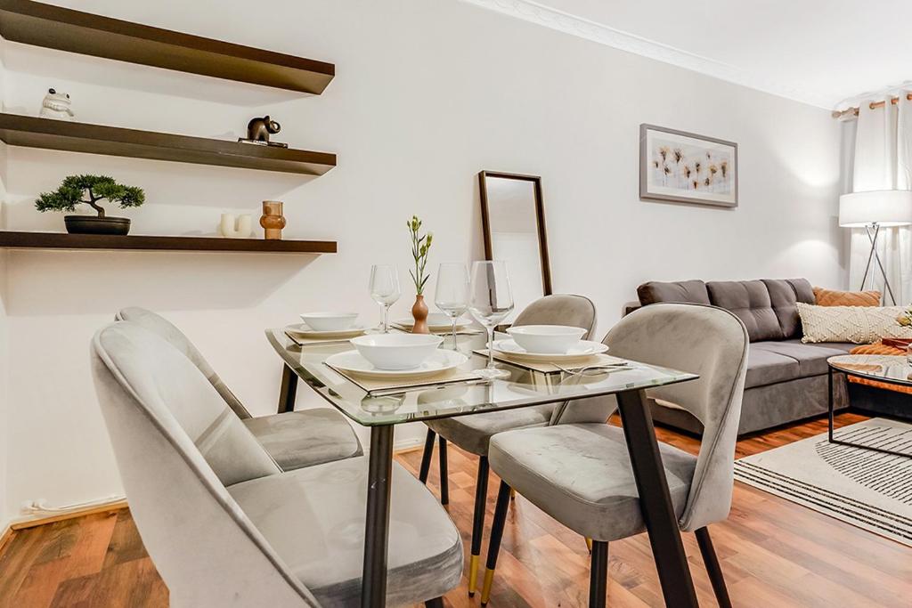 a dining room with a table and chairs and a couch at Spacious 1 Bed next to Baker St in London