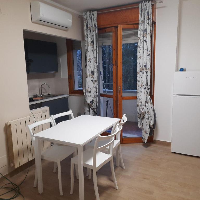 a white table and chairs in a kitchen with a window at Da Debbyquattro in Pisa