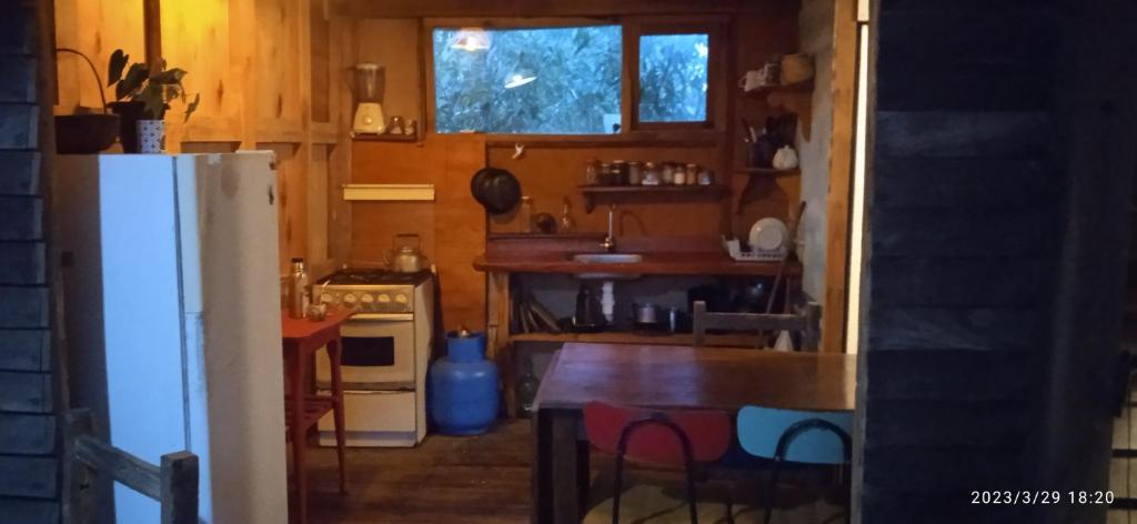 una pequeña cocina con mesa y nevera en Magavilla en Barra de Valizas