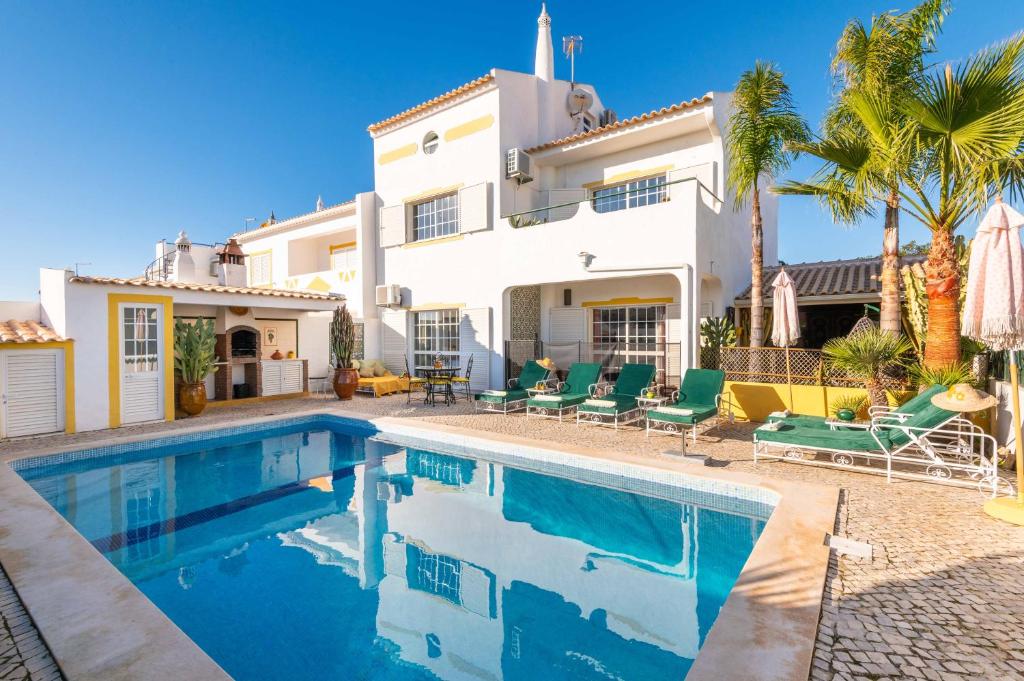 eine Villa mit einem Swimmingpool vor einem Haus in der Unterkunft Villa Galé Sun - Luxury, 5bed with free wifi, AC, private pool, 5 min from the beach in Guia