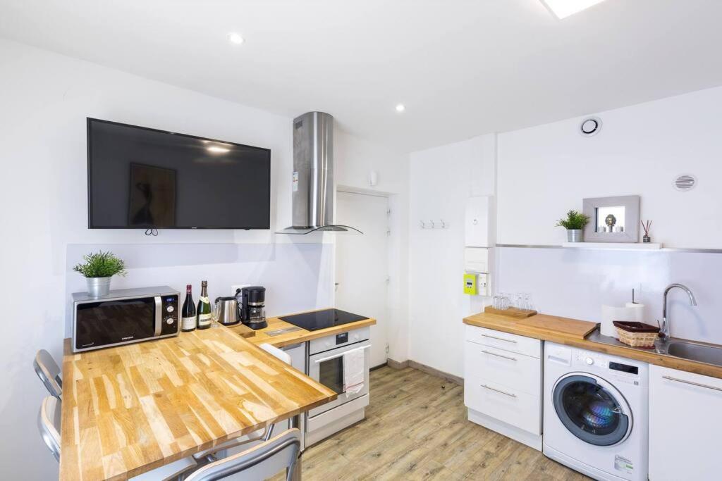 une cuisine avec un comptoir en bois et un évier dans l'établissement Eclipsa - Appartement de charme centre-ville, à Reims