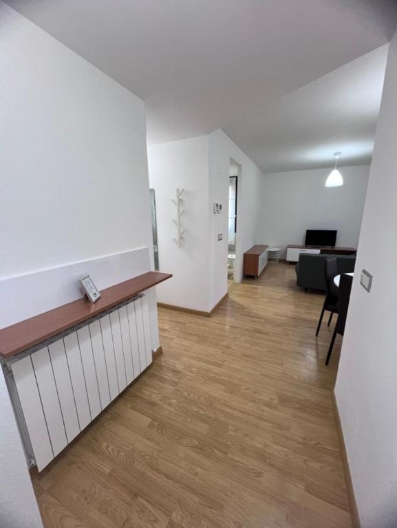 an empty living room with white walls and wood floors at Apartamento en Sabiñánigo para grupos con amplia y soleada terraza in Huesca