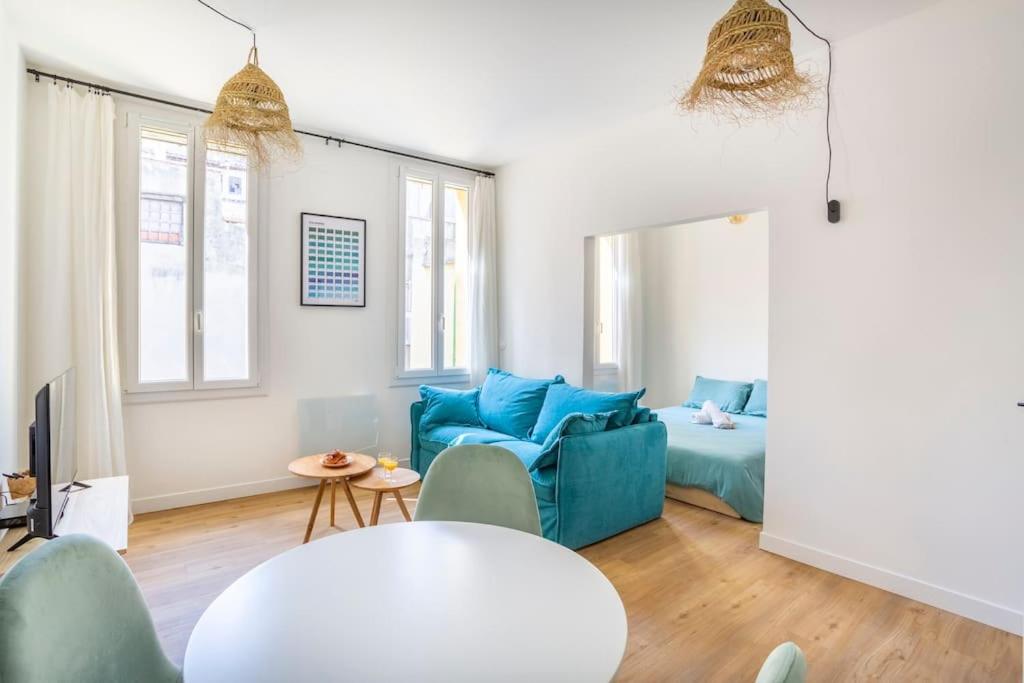 - un salon avec un canapé bleu et un lit dans l'établissement 14 THU Happynest, charmant appartement coeur de Marseille, à Marseille