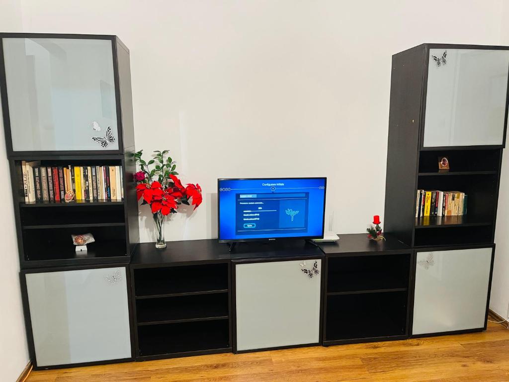 a desk with a computer and a tv on it at Apartament Soseaua Stefan cel mare in Bucharest