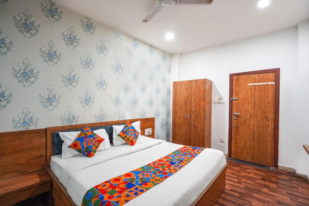 a bedroom with a large bed with a wooden headboard at FabExpress The Rawal Palace in Surat