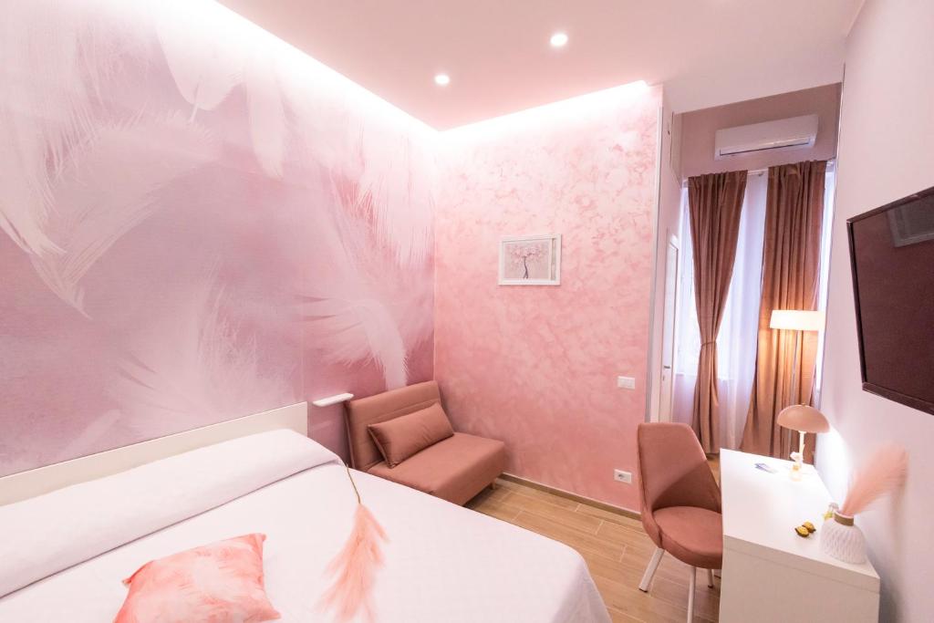 ein Hotelzimmer mit einem Bett und einem Stuhl in der Unterkunft Enchanting Suites Salerno in Salerno
