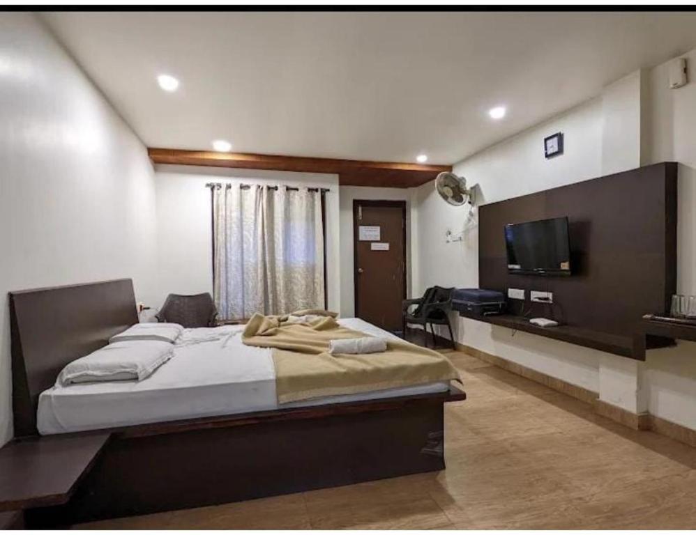 a bedroom with a large bed and a flat screen tv at Sea Lounge, Port Blair in Port Blair